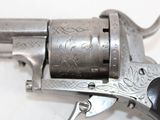 a silver revolver with a black handle on a white surface