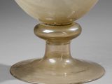 a glass bowl sitting on a pedestal on a table