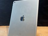 an apple ipad sitting on top of a wooden table next to a black wall