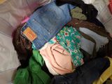 a pile of clothes in a basket on a bed