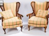 pair of antique cane back wing chairs with upholstered cushions