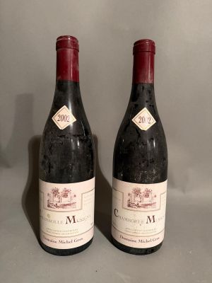 two bottles of wine sitting on top of a table next to each other