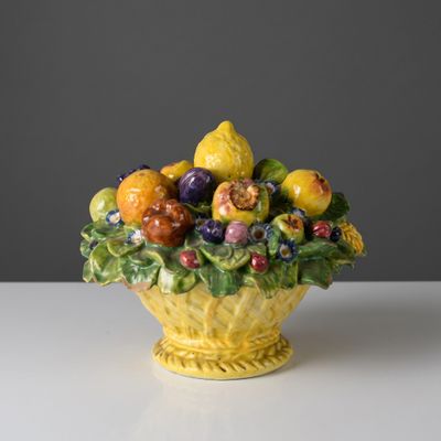 un saladier jaune rempli de fruits et de légumes posé sur une table