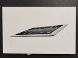an apple ipad box sitting on top of a table next to a clock