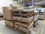 a large stack of pallets in a warehouse with a bucket on the floor