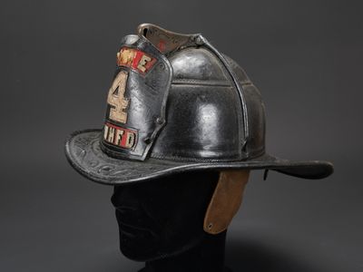 casque de pompier posé sur la tête d'un mannequin, sur fond gris