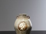 a vase with a picture of a man on it on a table