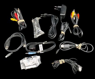 Lot de divers câbles et accessoires pour consoles de salon.