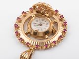 an image of a close up of a gold clock with pink stones on it
