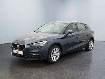 Une voiture grise est garée dans une pièce au sol noir.