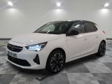 a white car is parked on a checkered floor in a showroom