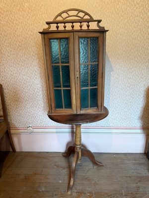 a small wooden table with a glass door on top of it