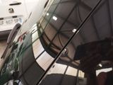 reflection of a person taking a picture of a car with a cell phone