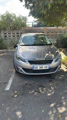 a silver car parked in a parking lot next to a fence