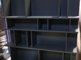 a black book shelf that is in the middle of a room