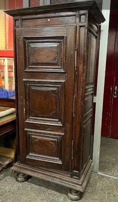 une grande armoire en bois dans une pièce dont la porte est rouge