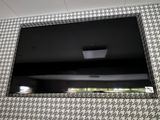 une télévision à écran plat fixée au mur au-dessus d'un lavabo