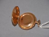 a small gold pocket watch with a rope around it