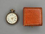 une petite boîte contenant une montre et une petite boîte sur laquelle est représentée une montre