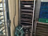 many trays of food sitting on a rack in a kitchen