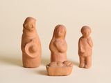 trois figurines en argile représentant une femme, un homme et un enfant