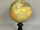 a small globe on a stand on a white surface
