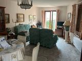 un salon avec une table, des chaises et un lustre