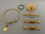several gold jewelry items including a ring, bracelet, and a coin