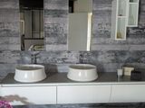 une salle de bains avec deux lavabos et deux miroirs fixés au mur