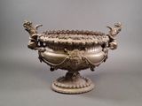 a large silver vase with a bird on it