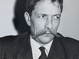 black and white photograph of a man with a mustache in a suit