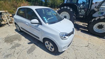 a small white car parked next to a tractor