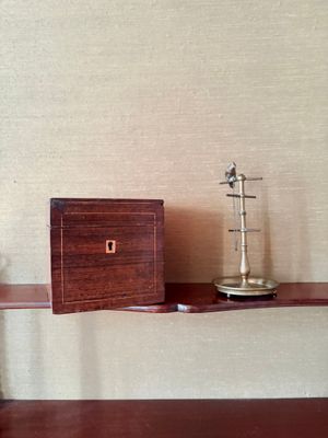 une étagère en bois sur laquelle sont posés une horloge et une boîte