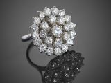 une image d'une bague sertie de diamants sur une surface réfléchissante