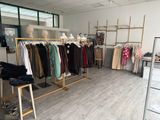 a room with a rack of clothes and clothes on display