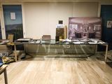 a desk with a glass top and a picture on the wall