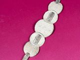 a picture of a silver and white object on a pink surface
