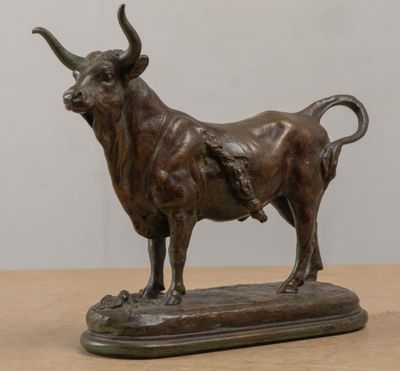bronze statue of a bull on a wooden base on a table