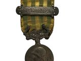 une vieille médaille surmontée d'une autre médaille, sur fond blanc