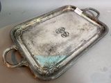 a silver tray with two handles on a table
