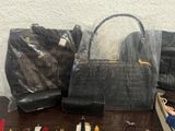 many bags and purses sitting on a table