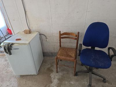 une chaise bleue et un réfrigérateur blanc dans une pièce