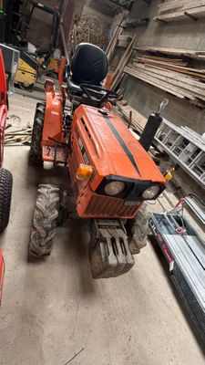 un tracteur rouge garé à côté d'un camion rouge dans un garage