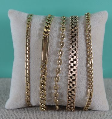 a close up of a pillow with a bunch of gold chains on it