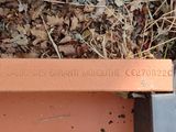 a bench that is sitting on the ground next to a pile of leaves