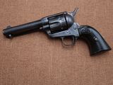 un gros plan d'un revolver posé sur une surface marron