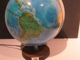 un petit globe bleu et vert posé sur un socle en bois