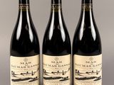 trois bouteilles de vin posées sur une table l'une à côté de l'autre