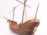 a wooden model of a ship on a white surface