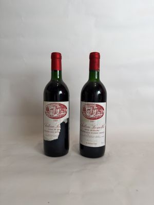 two bottles of red wine sitting next to each other on a table